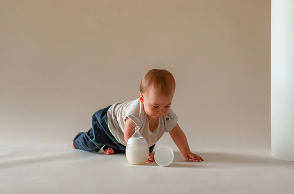 biberon Elhée 240 ml à coté d'un bébé à quatre pattes